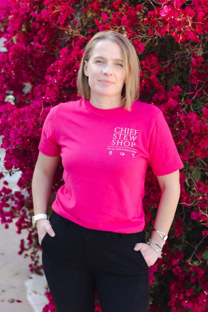 Portrait of Clair of Chief Stew Shop wearing her pink branded tee shirt posing in front of Bougainvillea during her personal branding shoot. 