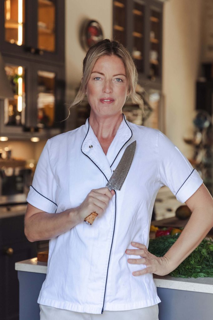 Private chef Ida in kitchen holding knife for personal branding shoot in Mallorca