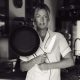 Private chef Ida in kitchen holding pan and knife for personal branding shoot in Mallorca